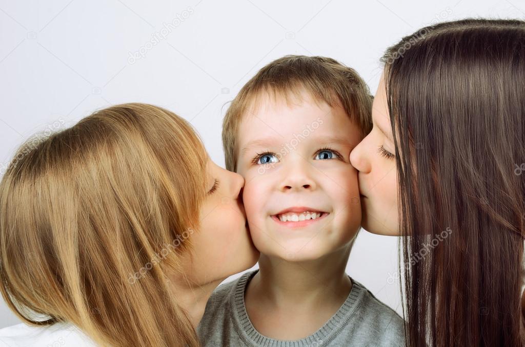 two girls kissing little cheerful boy