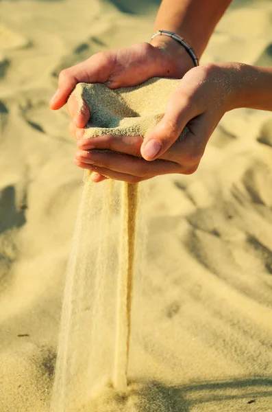 砂は、女性の手の注ぐ — ストック写真