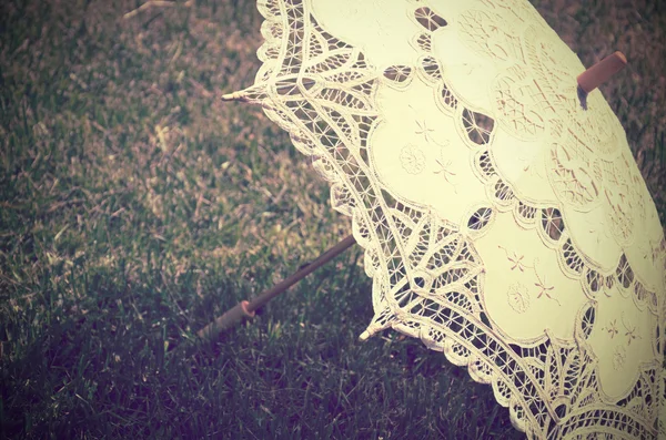 Кружевной зонтик на траве. тонированный винтаж — стоковое фото