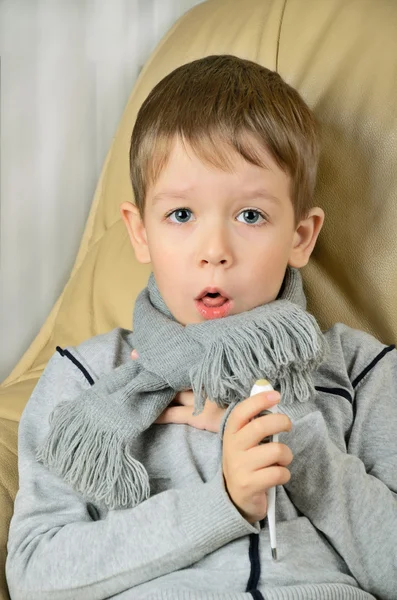 Menino doente tosse e segurando um termômetro — Fotografia de Stock