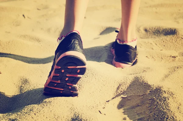 Tinted vanilla effect image girls feet in sneakers go away on th — Stock Photo, Image