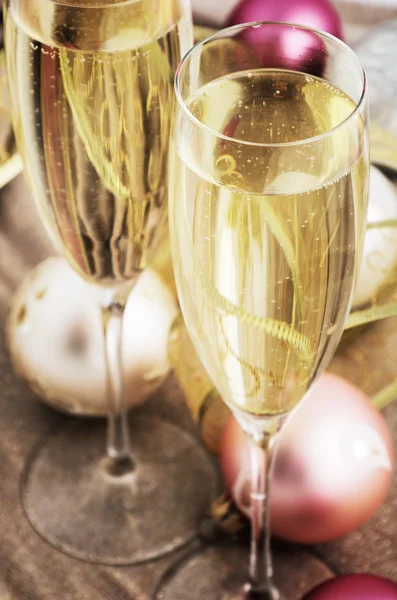 Tinted image two glasses with champagne and Christmas tree decor Royalty Free Stock Photos