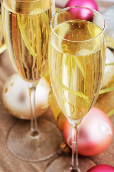 Two glasses with champagne and Christmas tree decorations on the Stock Image