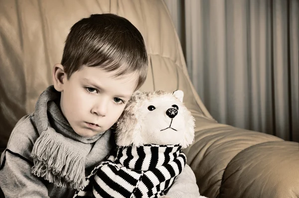 Getöntes Bild trauriger kleiner Junge umarmt Spielzeughund — Stockfoto