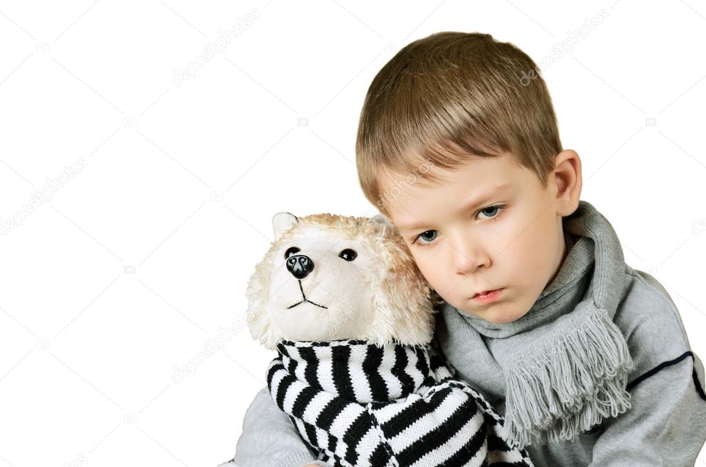 sad little boy hugging toy dog isolated on the white