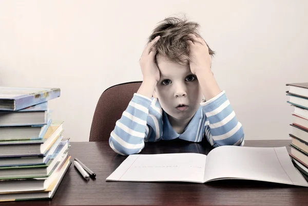 Bir masada oturan ve o için elele renkli görüntü yorgun çocuk