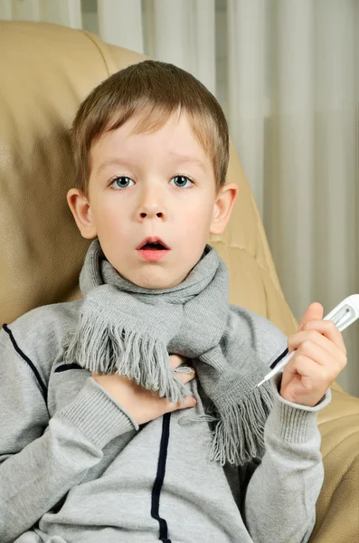 Boy coughing and holding a thermometer — Stock Photo, Image