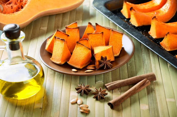 Kabak pişmiş, tarçın sopa, yıldız anason ve zeytinyağı bir ki üzerinde