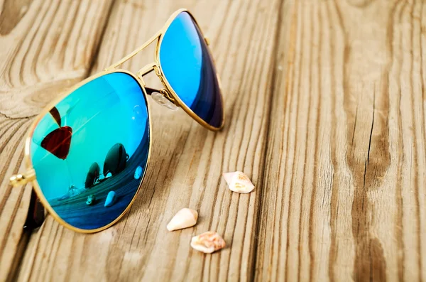 Blue mirrored sunglasses wiht reflection of martini glass on the