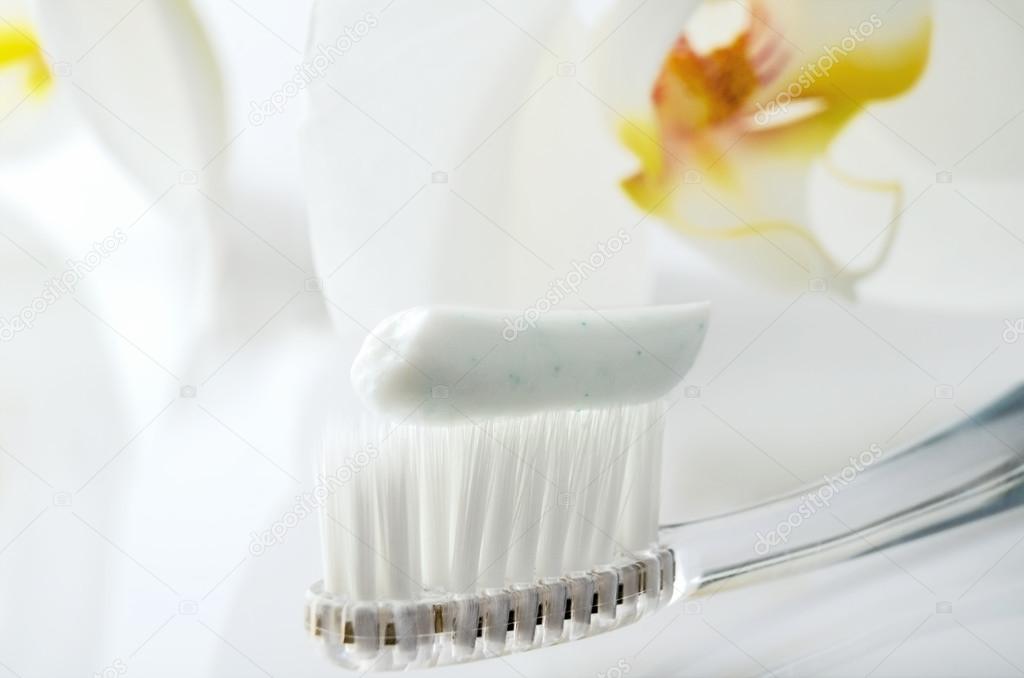 toothbrush with toothpaste on a white table against the backgrou