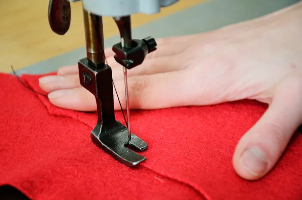 Part of sewing machine, red  woolen and female hand close up. ho — Stock Photo, Image