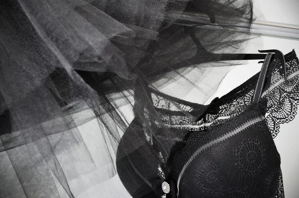 Black lace lingerie and tulle skirt tutu hanging on a hanger on — Stock Photo, Image