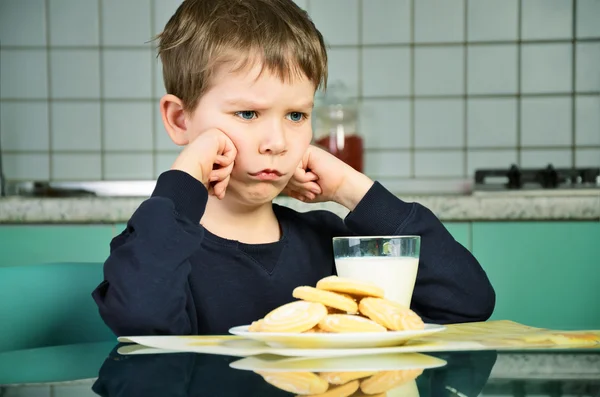 Kızgın küçük çocuk yemek masasında oturuyor. Yatay — Stok fotoğraf