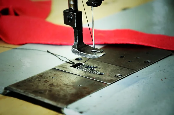 Part of sewing machine and red fabric — Stock Photo, Image