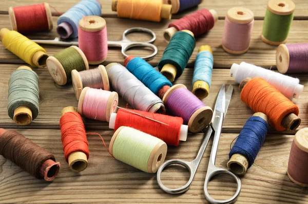 Needle thread scissors on a wooden table — Stock Photo, Image