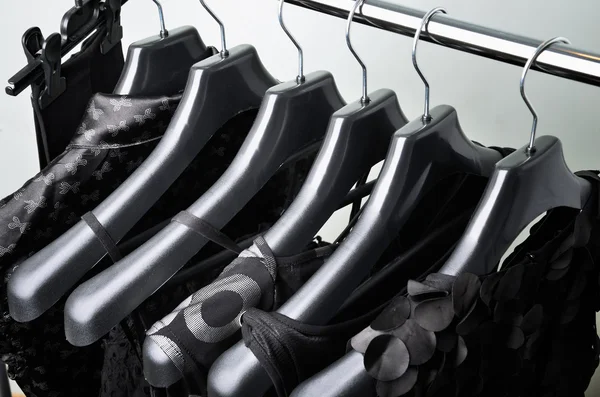 Black womens clothing hanging on the black plastic hanger top vi — Stock Photo, Image