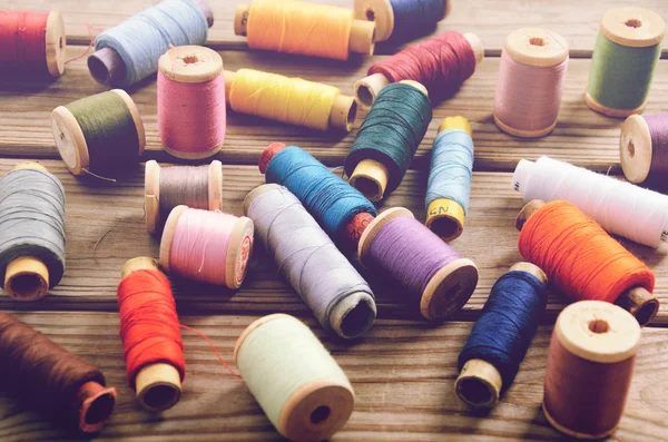 ahşap bir masa üstünde iğne iplik