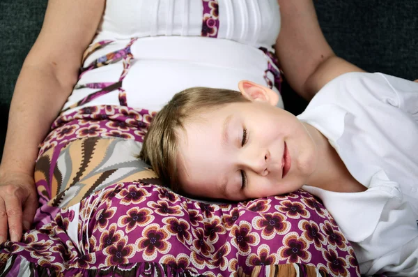 Happy smiling little boy sleeping near his grandmother — Stock Photo, Image