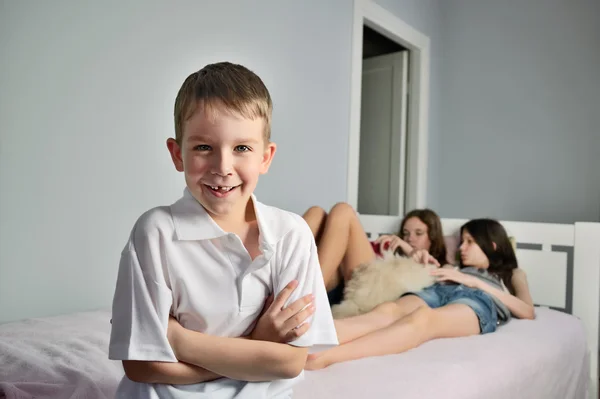 Cheerful boy foreground in the room whith girls — Stock Photo, Image