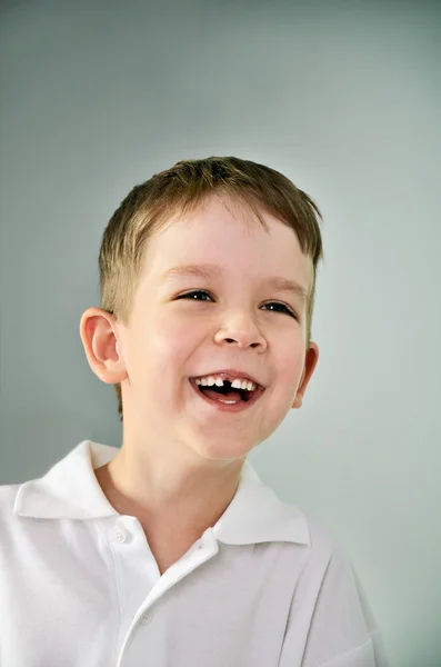 Retrato de niño riendo. el niño abrió la boca y perdió un diente —  Fotos de Stock