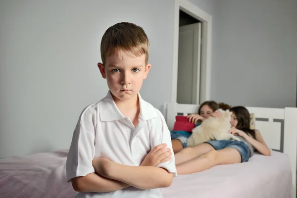 Sad boy with furrowed brows in the foreground in the room whith — Stock Photo, Image