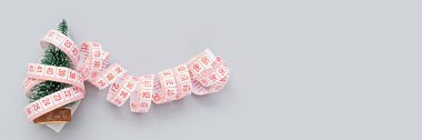 Egzersiz, Fitness ve Çalışan Mutlu Noeller ve Mutlu yıllar konsepti. Gri arka planda şerit ve noel ağacının fotokopi alanı ile ölçümü. Düz yatış, Üst Manzara, Genel Görünüm, Model