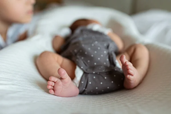 Kleine zus en haar pasgeboren broer. Een peuter die nieuwe broers en zussen ontmoet. Schattig meisje en pasgeboren baby jongen ontspannen in een slaapkamer. Gezin met twee kinderen thuis. Liefde, vertrouwen en tederheid — Stockfoto