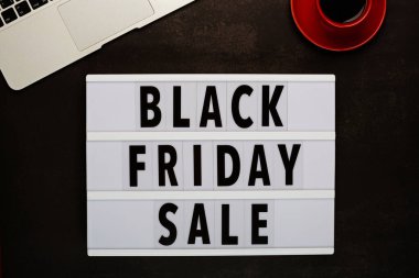 Kara Cuma için yaratıcı promosyon kompozisyonu ve siyah arka planda dizüstü bilgisayarı. Düz yatış, üst görünüm, genel görünüş, model, şablon. Asgari soyut arkaplan. İnternetten alışveriş, satış, tanıtım. Web afişi. Yüksek kalite fotoğraf