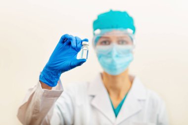Bej arka planda el ele tutuşan doktor ya da hemşire grip aşısı, bebek, erkek, kadın aşısı, ilaç ve uyuşturucu konsepti için kızamık şırıngası. Coronavirus covid-19 salgınına karşı aşı. Yüksek kalite fotoğraf