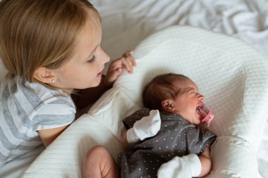 Küçük kız kardeşi ve yeni doğan erkek kardeşi. Küçük çocuk yeni kardeşle tanışıyor. Şirin bir kız ve yeni doğmuş bir erkek bebek yatak odasında rahatlar. Evde iki çocuklu bir aile. Aşk, güven ve şefkat kavramı