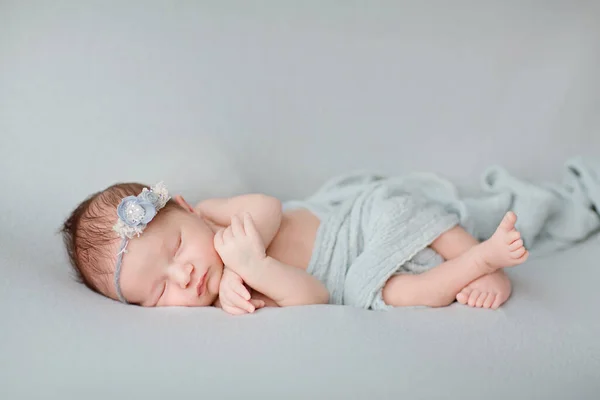 Gri battaniyenin üzerinde uyuyan yeni doğmuş şirin bir bebek. Bebek eşyaları paketleme şablonu. Sağlıklı ve tıbbi konsept. Boşluğu kopyala — Stok fotoğraf