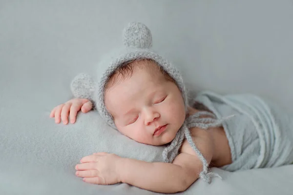 Gri battaniyenin üzerinde uyuyan yeni doğmuş şirin bir bebek. Bebek eşyaları paketleme şablonu. Sağlıklı ve tıbbi konsept. Boşluğu kopyala