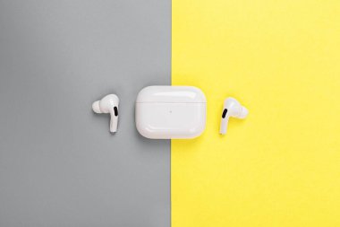 Masaüstü dairesi kablosuz kulaklıklarla doluydu. 2021 yılının renkleri: nihai gri ve aydınlatıcı. Renk konsepti, kopyalama alanı ile modelleme