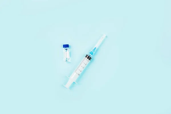 Плоский шар вакцини проти коронавірусу ковід-19 з шприцом, маскою для обличчя. Макет з простором для копіювання, видом зверху, накладним — стокове фото