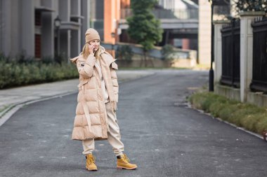 Dışarıda cep telefonu kullanan bir kadın. 2021 yılının rengi: nihai gri. Renk konsepti, kopyalama alanı ile modelleme