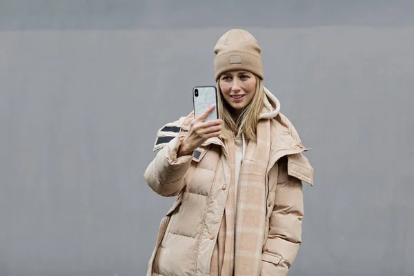 Mujer usando teléfono móvil al aire libre. Color del año 2021: gris final. Concepto de colores de moda, maqueta con espacio de copia — Foto de Stock