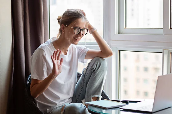 Work from home during coronavirus quarantine. Business Woman using laptop on kitchen. Freelancer talks to colleagues online at video chat. Stay at home during covid-19 concept