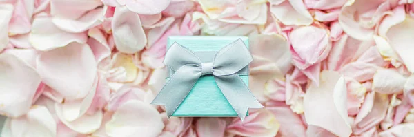 선물 상자 로즈 꽃잎에 놓여 있는 핑크 색 커버, 휴일 배경. — 스톡 사진