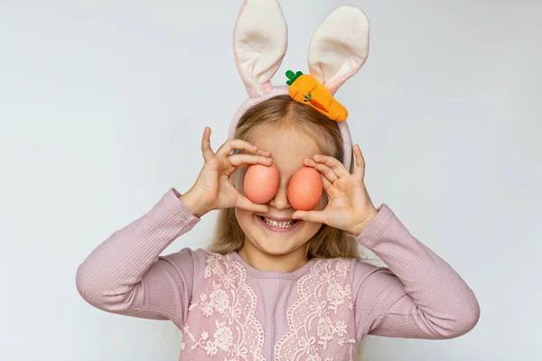 Linda niña con orejas de conejo sosteniendo huevo de Pascua, aislado sobre fondo blanco. Adorable niño celebrar vacaciones de Pascua — Foto de Stock