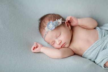 Gri battaniyenin üzerinde uyuyan yeni doğmuş şirin bir bebek. Bebek eşyaları paketleme şablonu. Sağlıklı ve tıbbi konsept. Boşluğu kopyala