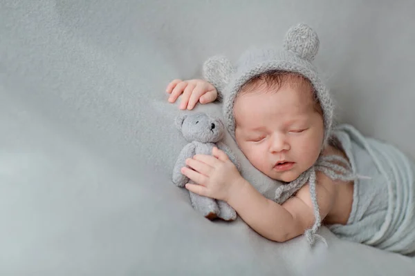 Gri battaniyenin üzerinde uyuyan yeni doğmuş şirin bir bebek. Bebek eşyaları paketleme şablonu. Sağlıklı ve tıbbi konsept. Boşluğu kopyala