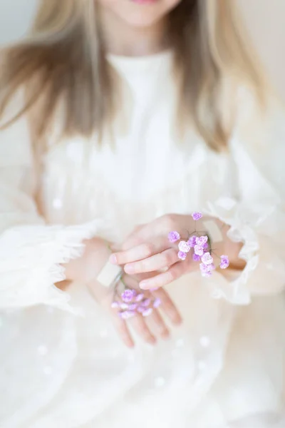 Retrato de cerca de una niña caucásica sonriente con flores de gypsophila aisladas sobre fondo gris. Modelo en estudio. Idea creativa de moda —  Fotos de Stock