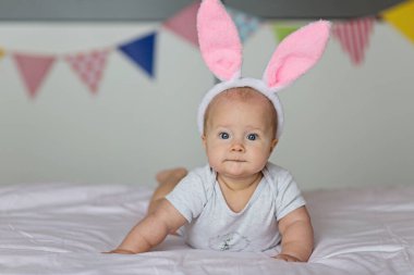 Kafkasyalı mutlu bir bebek. Altı aylık. Tavşan kulaklı, bantlı.