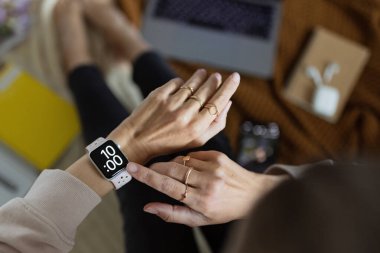 Akıllı saatin ekranında kadın eli görünümlü saatin yakın çekimi. Modern kablosuz teknolojiler. Blogger 'ın evde yaşam tarzı