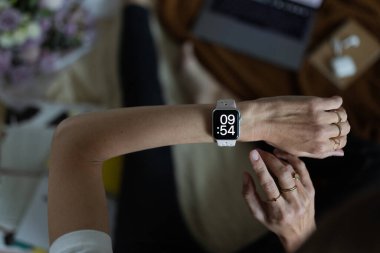 Akıllı saatin ekranında kadın eli görünümlü saatin yakın çekimi. Modern kablosuz teknolojiler. Blogger 'ın evde yaşam tarzı