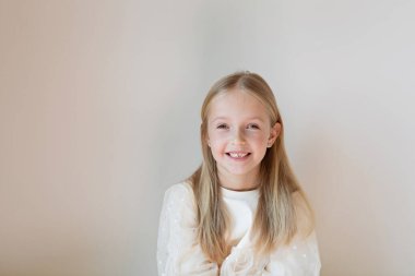 Bej arka planda sarı saçlı, fotokopi alanı olan şirin beyaz bir kız.. 