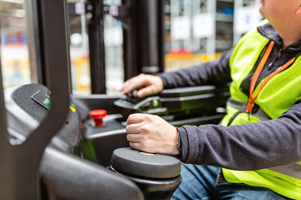 Depoda üniformalı bir çalışan modern otomatik depoda ulaşım kamyonunda çalışıyor. Depo, makine konsepti. Stokta lojistik.