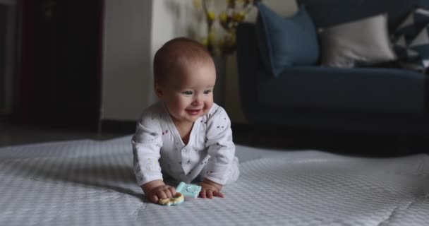 Auténtico primer plano Cute Caucasian Baby Girl seis meses de edad aprendiendo gatear en el suelo en la sala de estar en casa. Moción lenta. — Vídeos de Stock