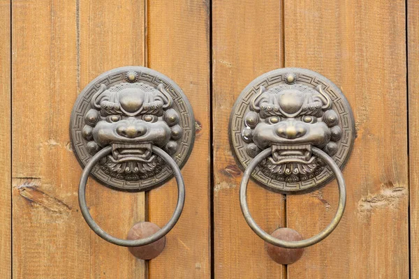 Bronze door handle muzzle Chinese dragon on the background of brown wooden boards.