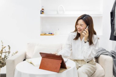 Küçük bir iş kurun, akıllı telefon ya da tablet kullanan Çinli genç girişimci paket ürün kutusu hazırlamak için online alışveriş siparişlerini alıp kontrol edin. çevrimiçi satış kavramı